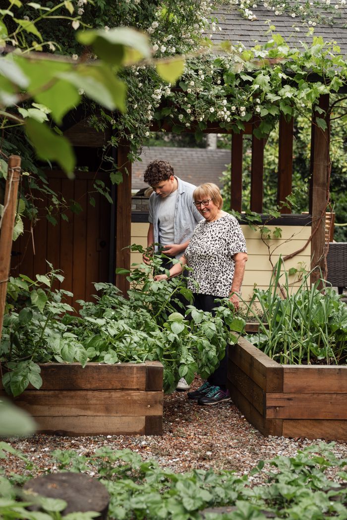 Two people in a lush garden, engaging in gardening activities.